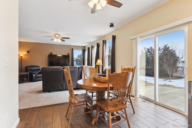 dining space with wood-type flooring and ceiling fan