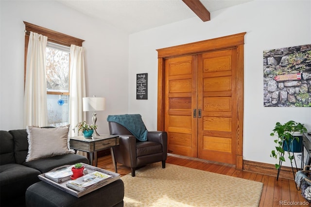 living room featuring beam ceiling and hardwood / wood-style floors