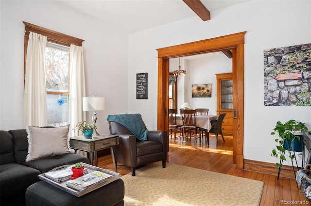 living room featuring beamed ceiling and wood-type flooring