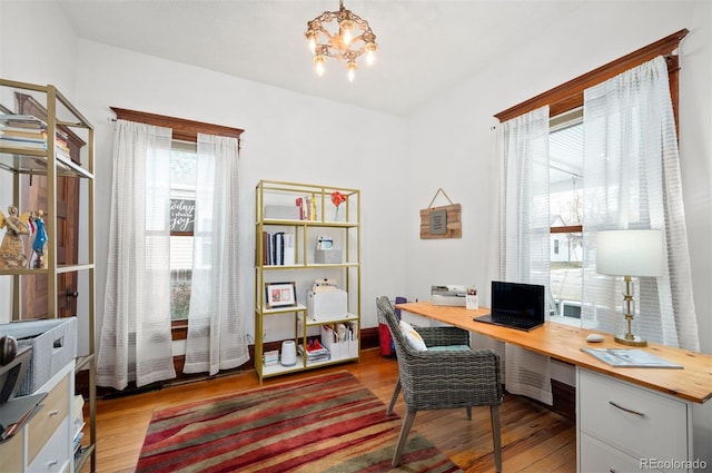 office area with hardwood / wood-style flooring, built in desk, and a chandelier