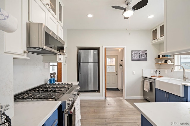 kitchen featuring stainless steel appliances, blue cabinetry, and white cabinets