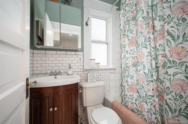 bathroom featuring vanity, toilet, tile walls, and backsplash