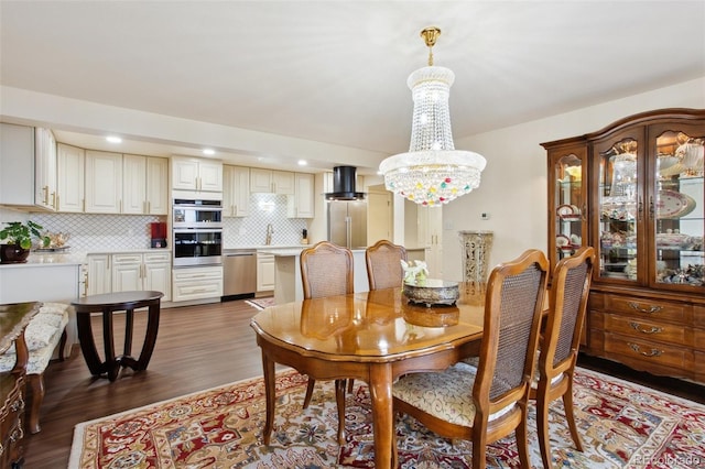 dining room with a notable chandelier, wood finished floors, and recessed lighting