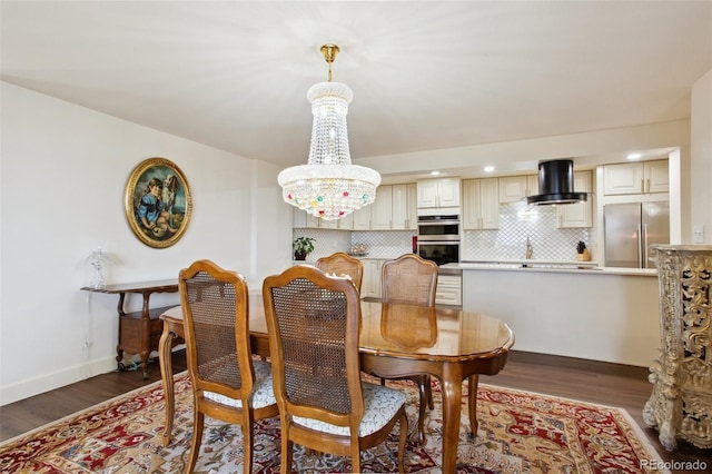 dining room featuring an inviting chandelier, baseboards, and wood finished floors