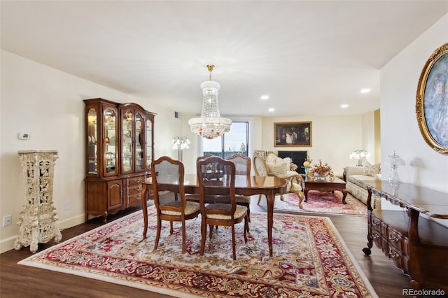 dining space with baseboards, dark wood finished floors, a notable chandelier, and recessed lighting