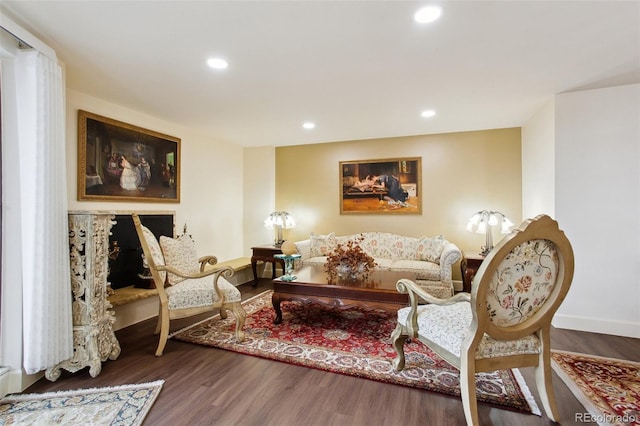 living area featuring baseboards, wood finished floors, and recessed lighting