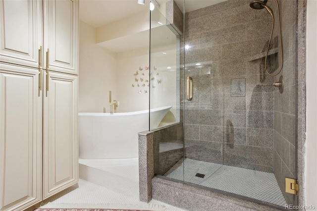 full bathroom featuring a freestanding tub and a shower stall