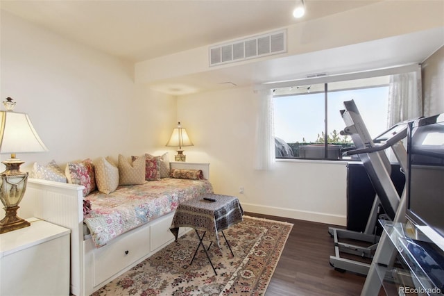 living room with wood finished floors, visible vents, and baseboards