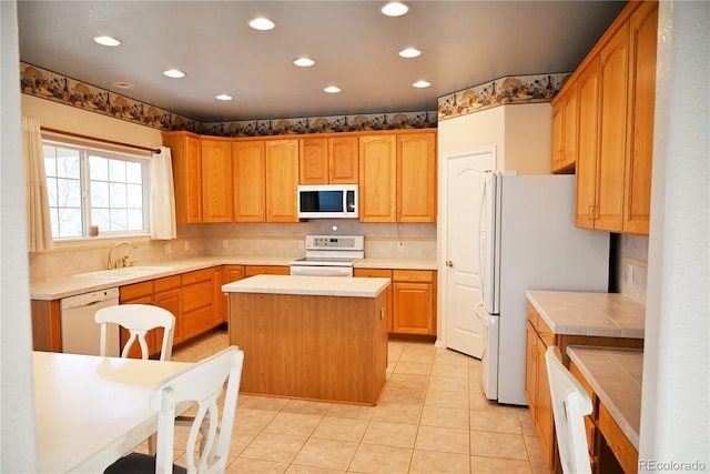 kitchen with a center island, light tile patterned flooring, white appliances, and sink