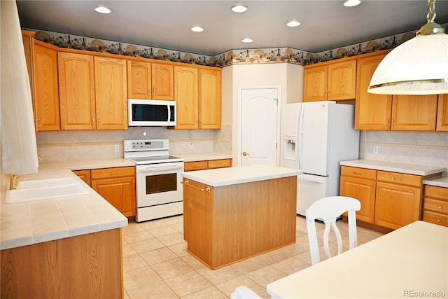 kitchen with a center island, sink, hanging light fixtures, white appliances, and light tile patterned flooring