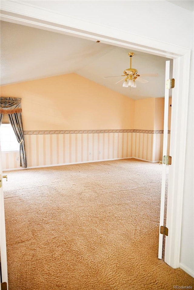 carpeted empty room with ceiling fan and vaulted ceiling