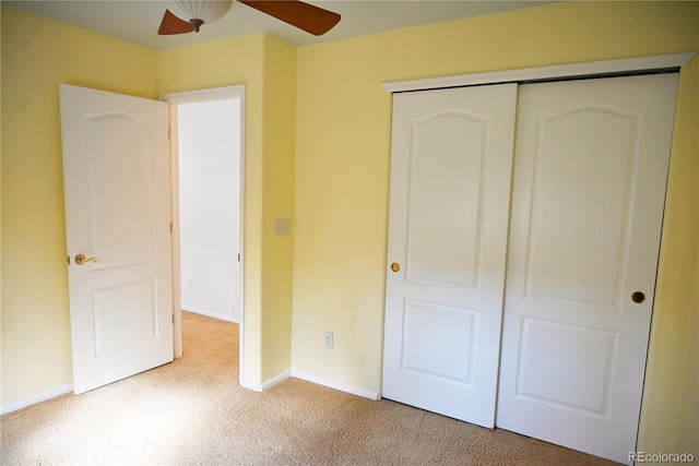 unfurnished bedroom featuring carpet floors, a closet, and ceiling fan