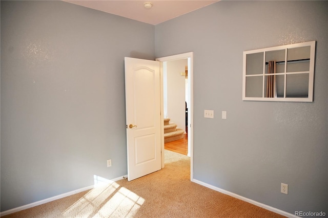 unfurnished room featuring light colored carpet