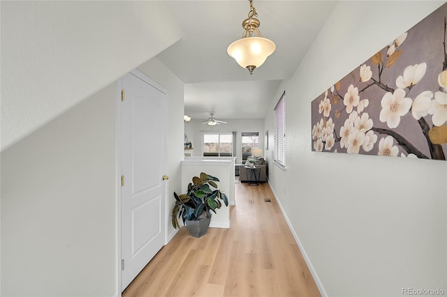corridor with baseboards and light wood-type flooring