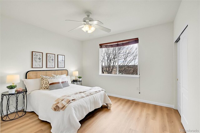 bedroom featuring baseboards, light wood-style floors, and ceiling fan