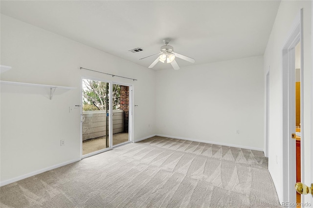 carpeted empty room with baseboards, visible vents, and a ceiling fan