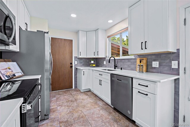 kitchen featuring backsplash, light tile patterned floors, appliances with stainless steel finishes, and white cabinetry