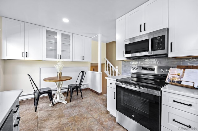 kitchen featuring appliances with stainless steel finishes, white cabinetry, backsplash, and light tile patterned floors