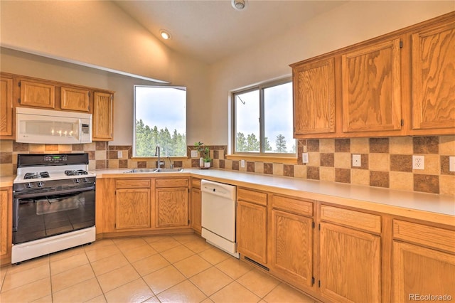 kitchen with sink, white appliances, light tile patterned floors, tasteful backsplash, and vaulted ceiling