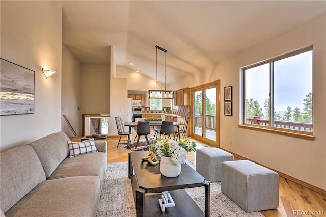 living room featuring lofted ceiling and light hardwood / wood-style flooring