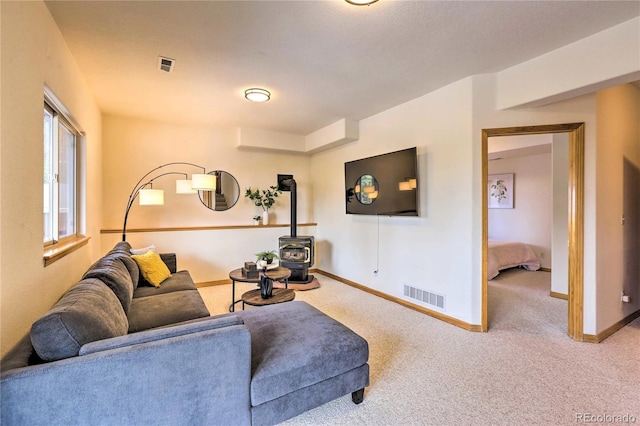 carpeted living room featuring a wood stove