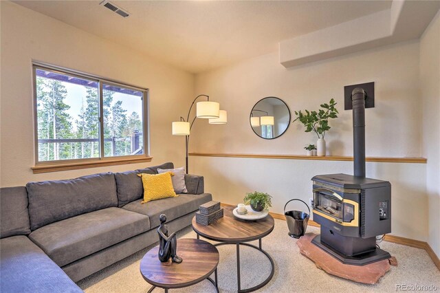 living room with carpet floors and a wood stove