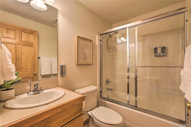 full bathroom with enclosed tub / shower combo, vanity, and toilet