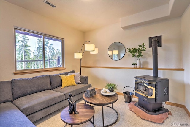 carpeted living room featuring a wood stove