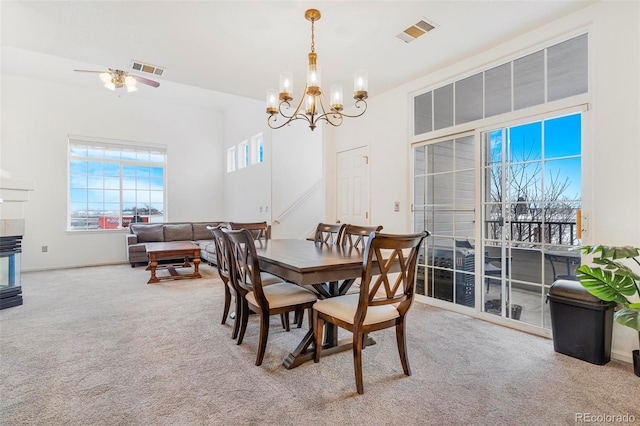 dining area featuring a notable chandelier and light colored carpet