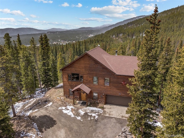 72 Overlook Ct, Idaho Springs, CO 80452 - view of front facade with stone siding, a garage, a mountain view, a forest view, and driveway