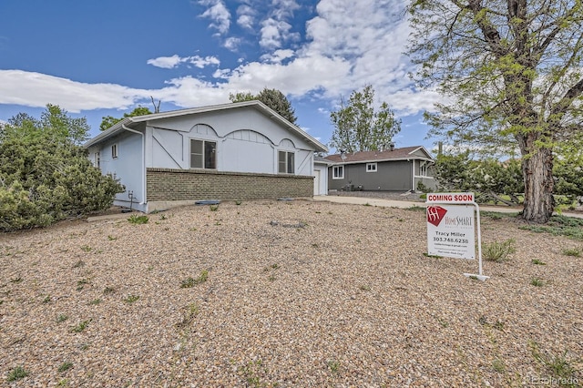 view of front of home featuring stucco siding and brick siding