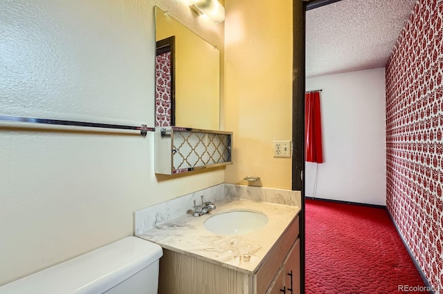 bathroom featuring a textured ceiling, toilet, and vanity