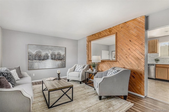 living room featuring wood walls and light hardwood / wood-style flooring