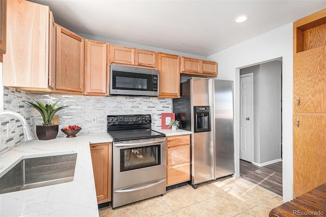 kitchen with tasteful backsplash, sink, light tile patterned floors, and appliances with stainless steel finishes