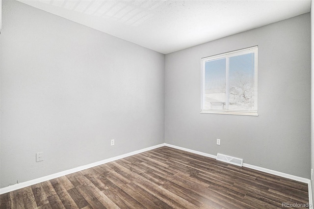 empty room featuring dark wood-type flooring