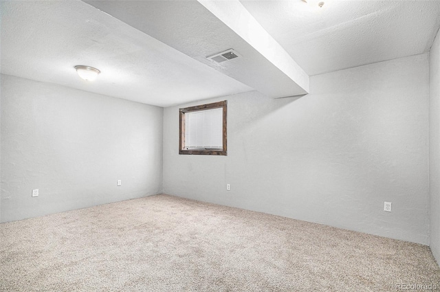 carpeted empty room with a textured ceiling