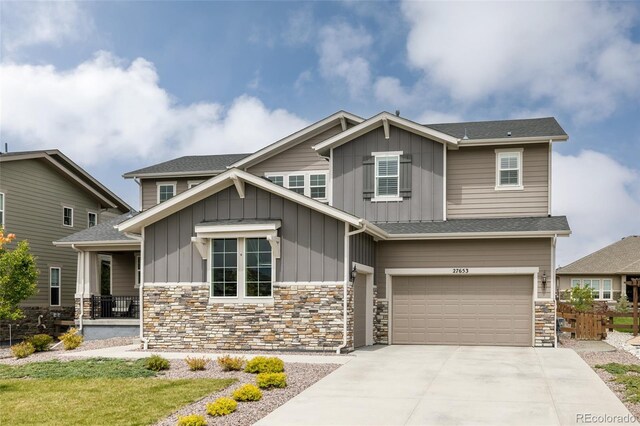 27653 E Euclid Dr, Aurora, CO 80016 - craftsman-style home with board and batten siding, a garage, driveway, and stone siding