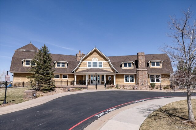 27653 E Euclid Dr, Aurora, CO 80016 - view of front of house with a chimney, a porch, a gambrel roof, and a shingled roof