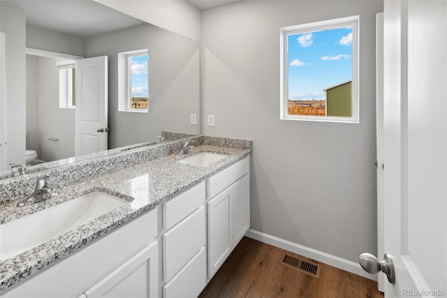 2145 Alyssa St, Fort Lupton, CO 80621 - full bath featuring wood finished floors, toilet, baseboards, and double vanity