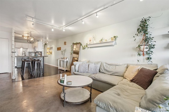 living room with rail lighting and sink