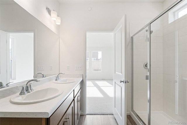 bathroom featuring hardwood / wood-style flooring, vanity, and walk in shower