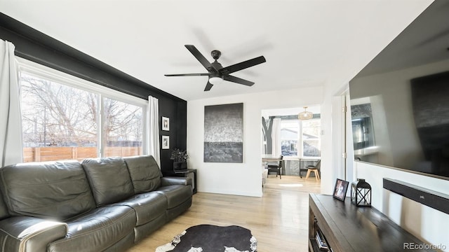 living room with light hardwood / wood-style floors and ceiling fan