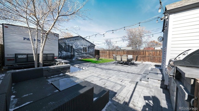 view of patio featuring an outbuilding and a grill