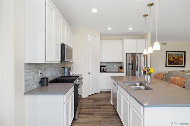 16341 Clayton St, Thornton, CO 80602 - kitchen with stainless steel appliances, dark wood-style flooring, a center island with sink, tasteful backsplash, and white cabinetry
