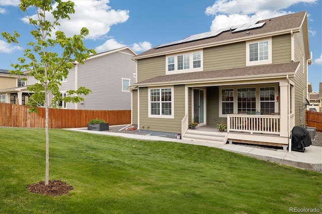 16341 Clayton St, Thornton, CO 80602 - back of property featuring roof mounted solar panels, a fenced backyard, and covered porch