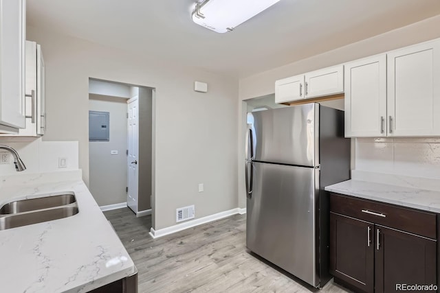 384 S Decatur St, Denver, CO 80219 - kitchen with freestanding refrigerator, backsplash, white cabinets, light wood-style floors, and light stone counters