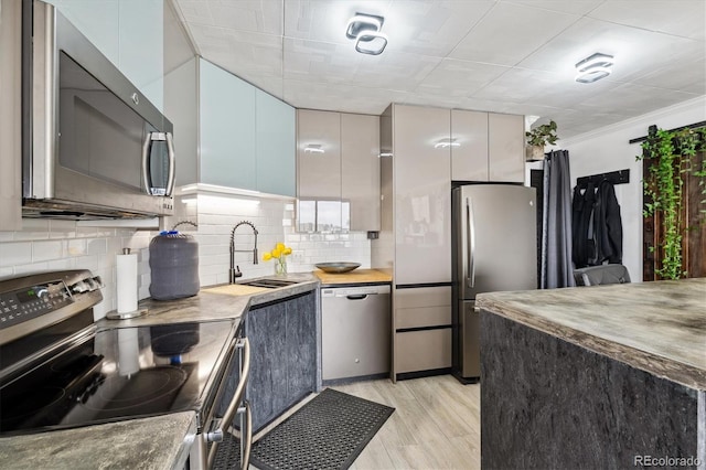 1301 Speer Blvd Unit 1108, Denver, CO 80204 - kitchen featuring stainless steel appliances, a sink, tasteful backsplash, light wood finished floors, and modern cabinets