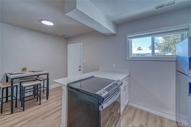 kitchen with black electric range, kitchen peninsula, white fridge, light hardwood / wood-style floors, and white cabinets