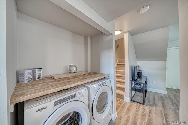 clothes washing area with washer and dryer and light wood-type flooring