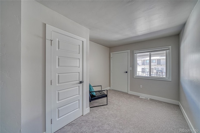 spare room featuring light colored carpet